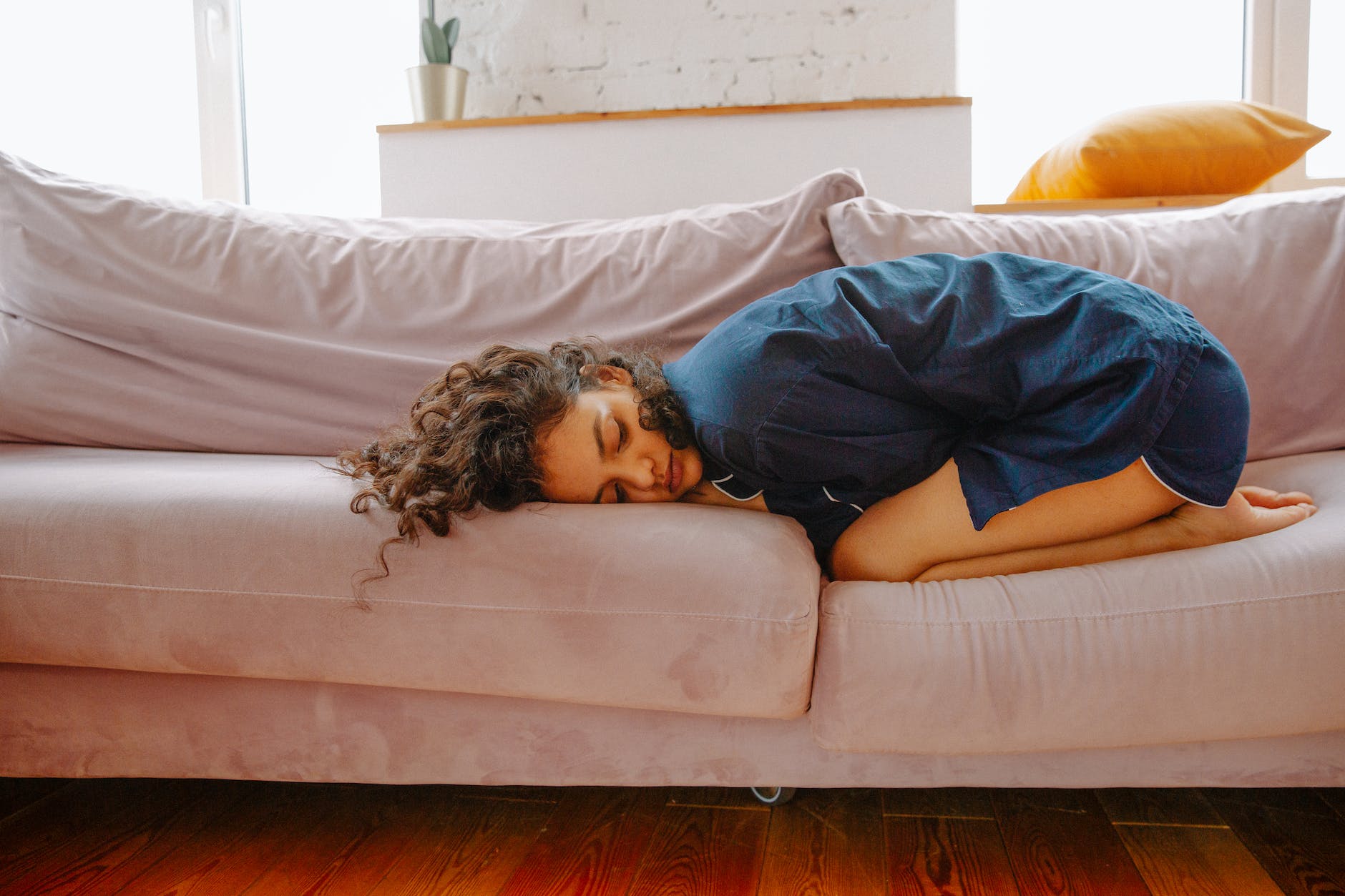 woman lying on couch with period pain
