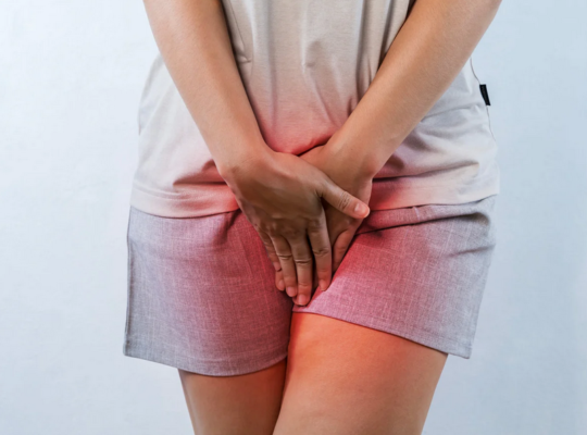 Middle-aged woman holding hands over pelvic area in pain